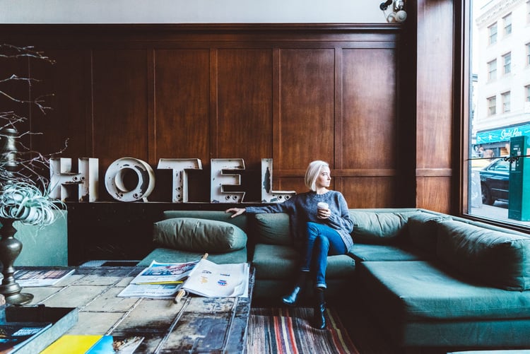 Woman Sitting on a Hotel Lobby Couch